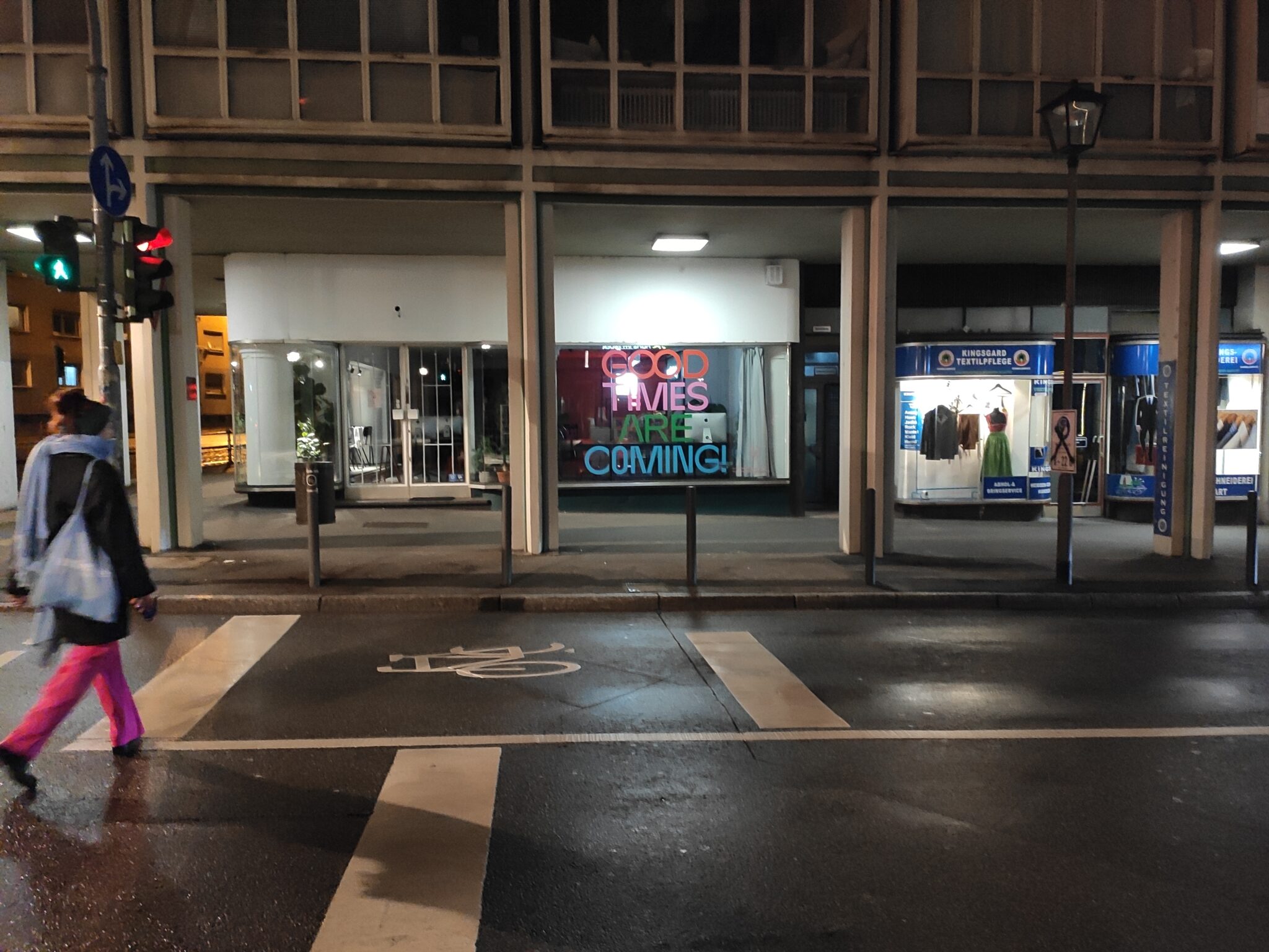 Eine Person überquert eine Straße bei Nacht.